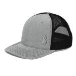 Grey black trucker hat with the paddle hands logo on the bottom left corner. Side profile.